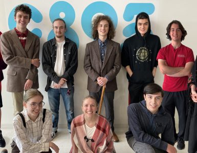 Photo of 10 high school students standing in front of a white wall with a large C89.5 logo.