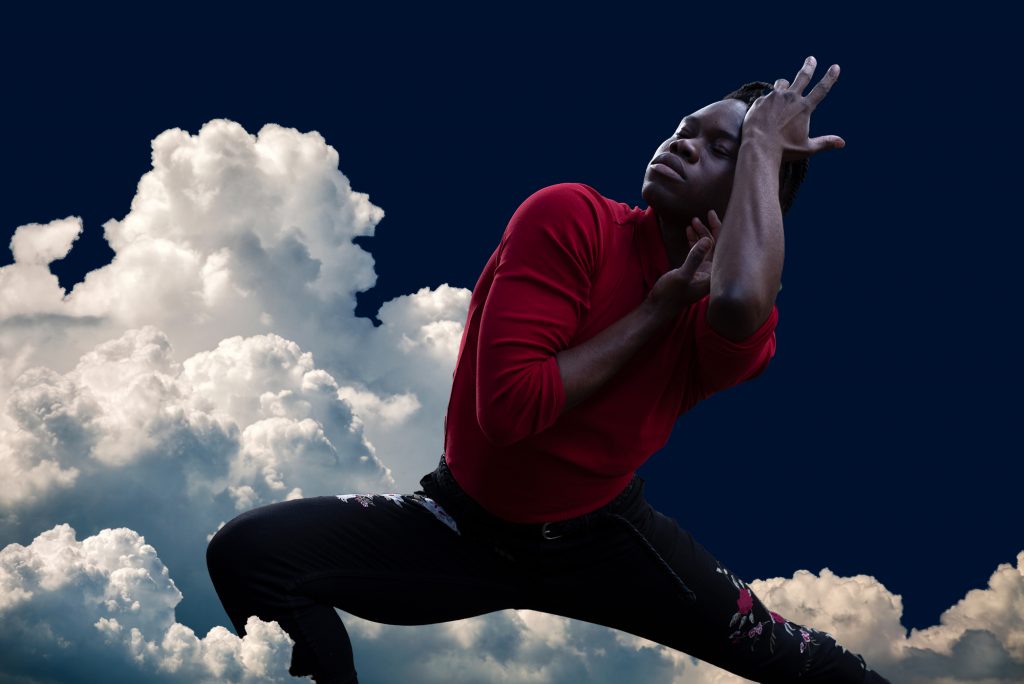 A photo of dancer David Rue against a sky