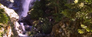 A cascading waterfall surrounded by rocks and trees.