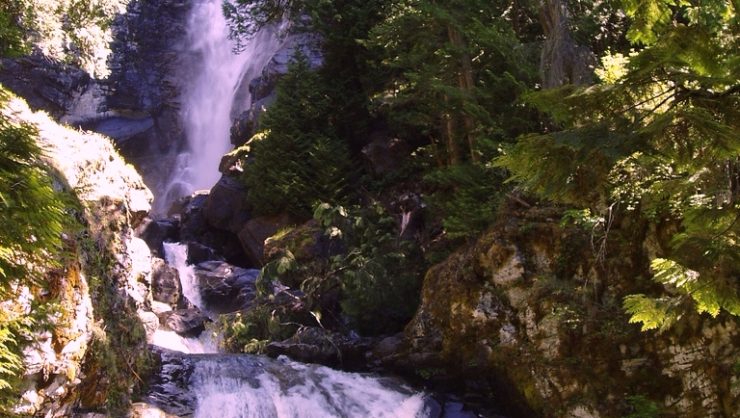 A cascading waterfall surrounded by rocks and trees.