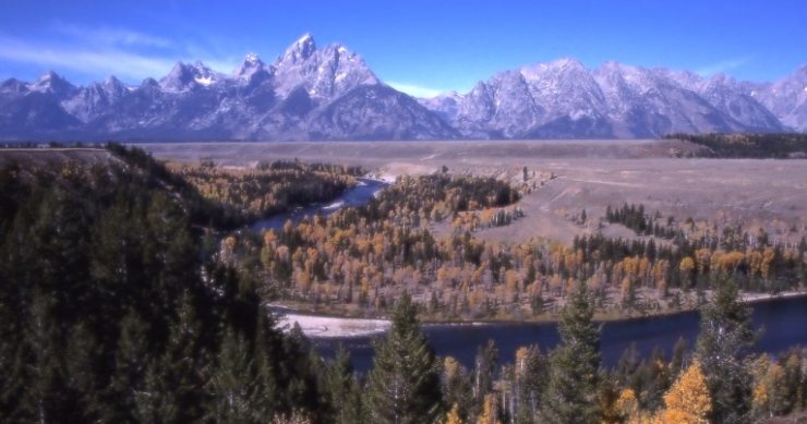 An autumn landscape with mountains and a winding river.