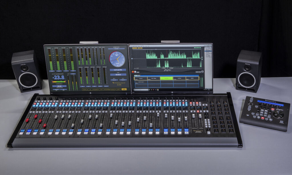 A photo of a Wheatstone digital mixing console. Sliding volume controls and buttons