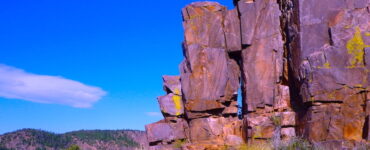 A solitary rock formation stands stoic against the backdrop of a vast desert landscape. The forces of nature have sculpted this ancient rock formation into a mesmerizing work of art, its weathered beauty a testament to the passage of time.