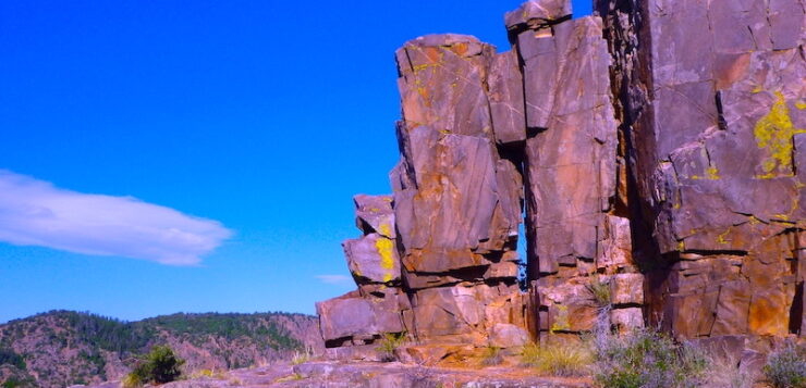 A solitary rock formation stands stoic against the backdrop of a vast desert landscape. The forces of nature have sculpted this ancient rock formation into a mesmerizing work of art, its weathered beauty a testament to the passage of time.