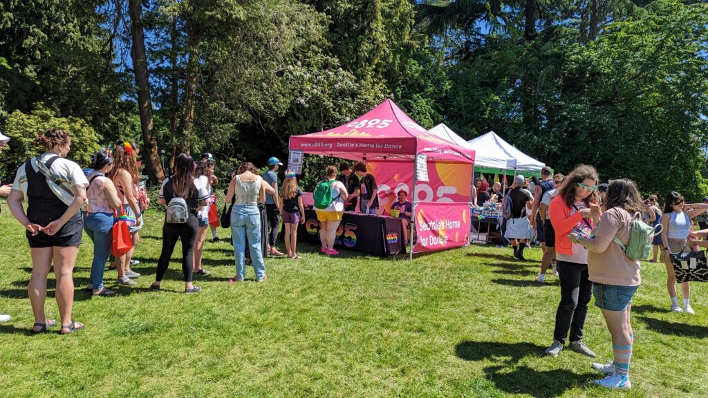 A line forming on a sunny day leading into the c895 tent