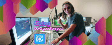 Person in a radio studio giving a thumbs up, with colorful graphics promoting the "Give Big" event scheduled for May 6-7, featuring the text "Giving looks good on you.
