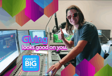 Person in a radio studio giving a thumbs up, with colorful graphics promoting the "Give Big" event scheduled for May 6-7, featuring the text "Giving looks good on you.
