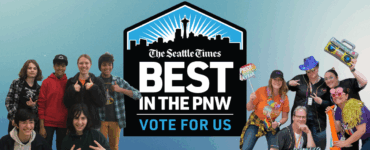 Group of people smiling and posing playfully with props, encouraging votes for 'The Seattle Times' as 'Best in the PNW'. Prominent blue logo in the center with text.