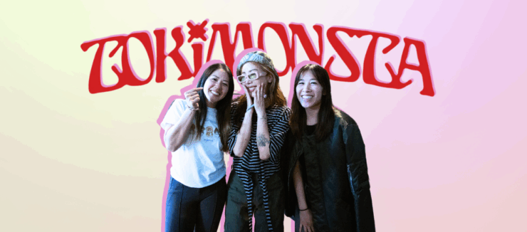 Three individuals posing with smiles in front of a neon sign that reads "TOKiMONSTA.