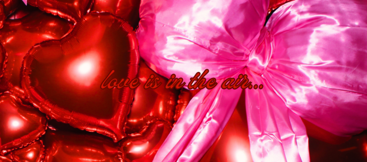An array of shiny red heart-shaped balloons with a prominent pink bow, featuring the phrase "love is in the air..." floating amidst them.