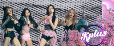 Four performers are on stage, dancing energetically against a black and white patterned backdrop. They wear stylish pink and black outfits. A graphic in the foreground features cherry blossoms and a tower, with the text "Kplus" inside a circle.