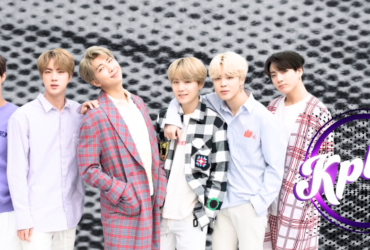 A group of people stand in a row, smiling, against a textured black and white background. They are dressed in stylish, colorful outfits. To the right, the word "Kplus" is displayed in a purple circle.