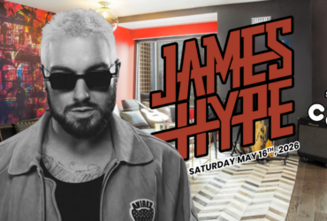 A person wearing sunglasses and a casual jacket is in the foreground, with a colorful, music-themed backdrop. In bold red letters, "James Hype" is displayed. Logos for "W Seattle" and "C 89.5" are visible. The date "Saturday, May 16th, 2026" is also included.