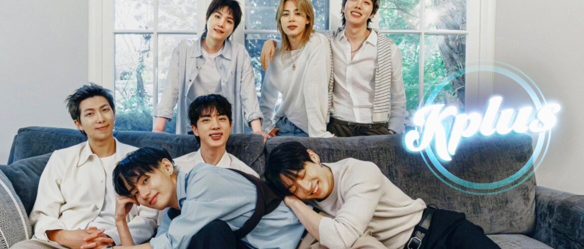 A group of six people smiling and sitting on a couch in a cozy, light-filled room with large windows. The word "Kplus" is displayed in the corner of the image.