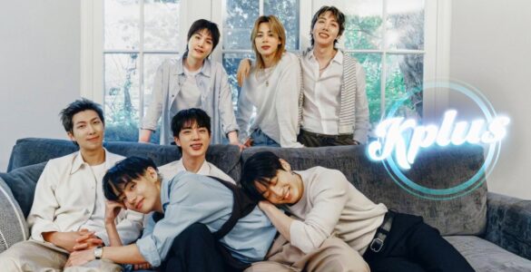 A group of six people smiling and sitting on a couch in a cozy, light-filled room with large windows. The word "Kplus" is displayed in the corner of the image.