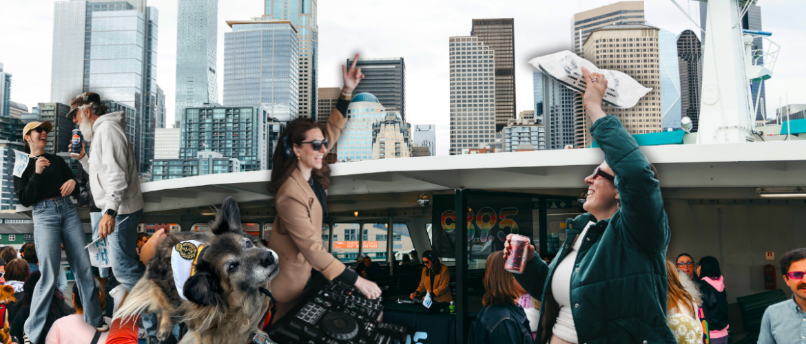 A crowded ferry deck with people taking photos and mingling, set against the backdrop of Seattle's skyline featuring tall buildings and landmarks. The top of the ferry's structure is visible, flying flags.