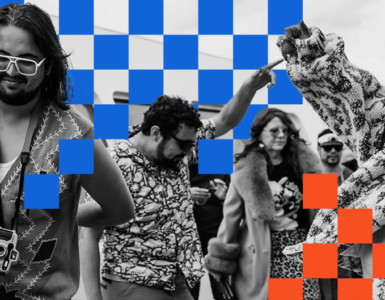 A group of people enjoy dancing with lively expressions. A person in the foreground wears large glasses and a camera around their neck. The image has a checkerboard overlay pattern in blue and orange squares.